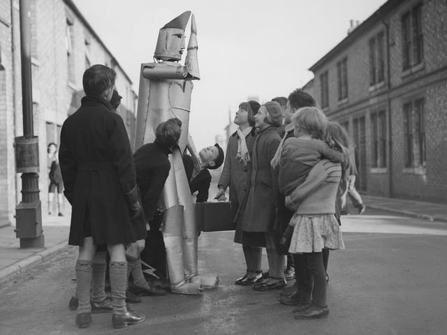 15th January 1939: The children of Kettering in Northamptonshire stare in amazement at a walking talking robot, the invention of local electrical engineer Charles Lawson. (Photo by Harry Todd/Fox Photos/Getty Images)