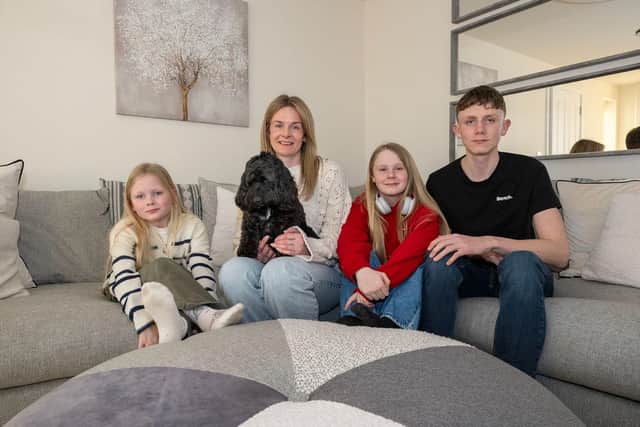 Aimee Fogg and her children and the dog in the lounge of their new house