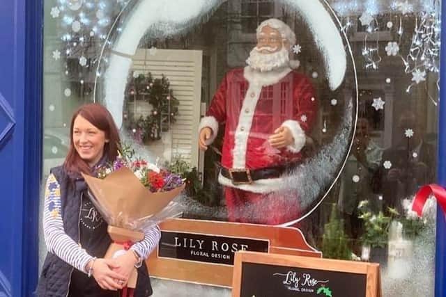 Owner Lyndsey Crosby with her competition-winning shop window, decorated for Christmas
