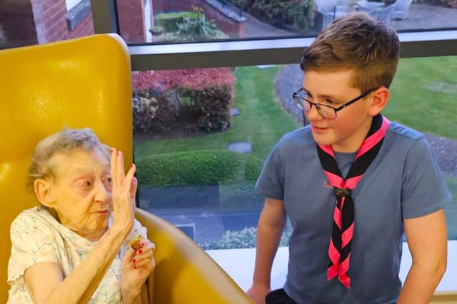 Delighted Elm Bank Care Home resident enjoying the evening with a young Scout