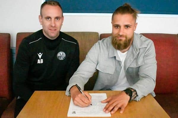 Matthew Lars Fossen signs for AFC Rushden & Diamonds under the watchful eye of boss Andy Burgess
