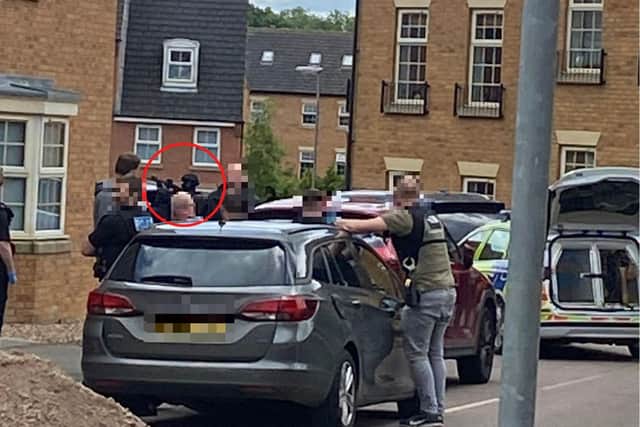 An armed officer has his weapon lifted
