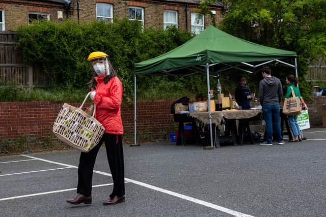 A woman wears a face shield, mask and gloves as she shops at Blackheath Farmers Market in London (Photo: Chris J Ratcliffe/Getty Images)