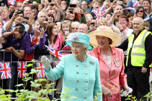 Her Majesty Elizabeth Queen II waves to crowds outside Corby International Swimming Pool and Corby Cube on June 2012