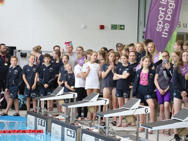 Swimmers watch the ceremony at Corby pool