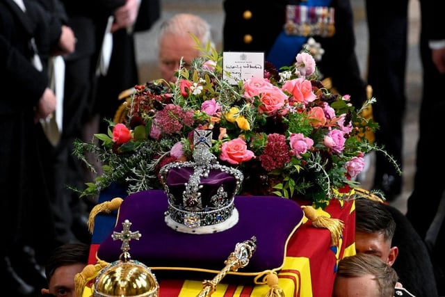 King Charles III walks alongside the coffin carrying Queen Elizabeth II with the Imperial State Crown resting on top as it departs Westminster Abbey during the State Funeral