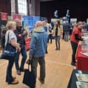 A lively travel fair buzzing with conversations as visitors explore destination booths and gather inspiration for their next adventure.