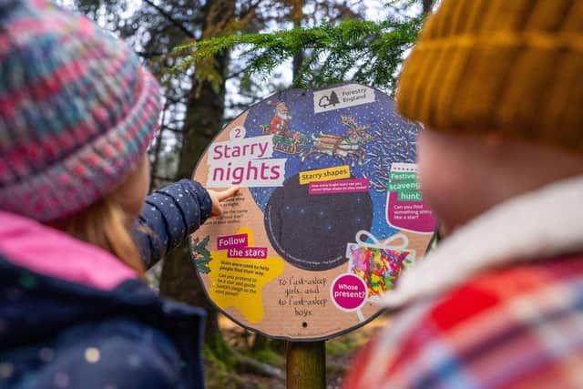 Two children look at a Stick Man trail panel.