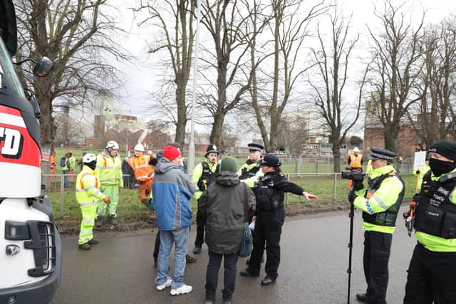 Pedestrians in the road are asked to move to allow work to start on the tree felling