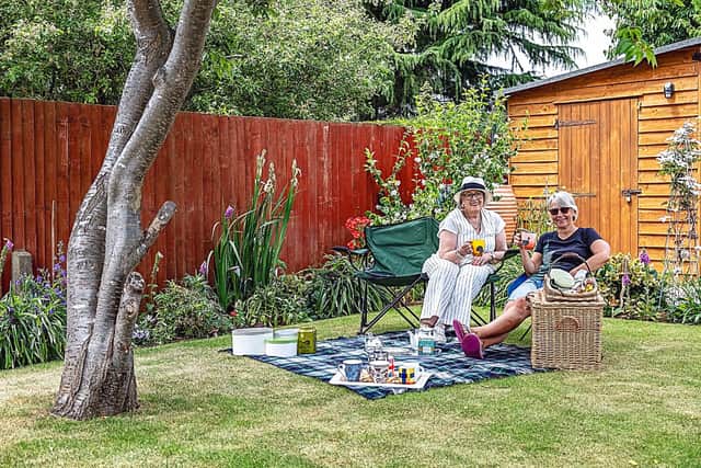 Pic 4) Liz Barnatt, left, chair of Higham Ferrers Tourism, takes a break with gardener Cathy Kennedy in Cathy’s showpiece garden.