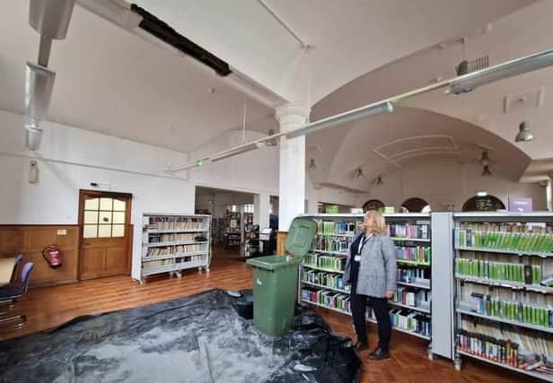 Cllr Helen Howell in the library where the ceiling fell in - and the bins collecting water