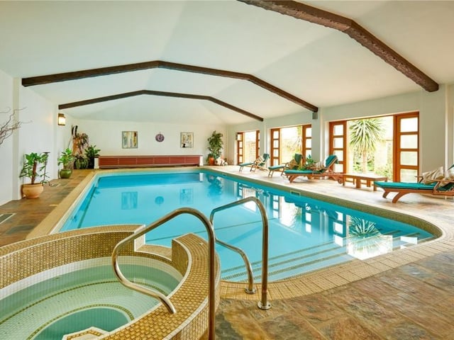 The home has traditional features as well as an indoor swimming pool, equestrian facilities and extensive parkland.