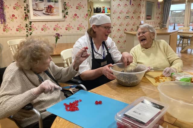 Residents and care colleagues helping make the winning cake!