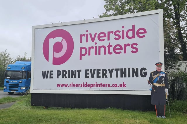 King Charles III next to a Riverside Printing billboard