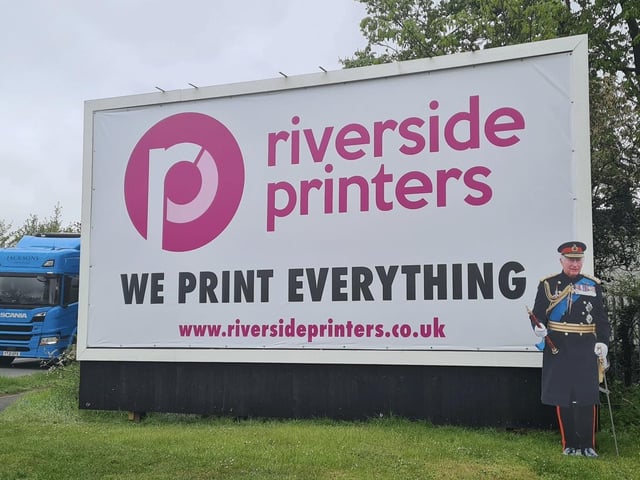 King Charles III next to a Riverside Printing billboard