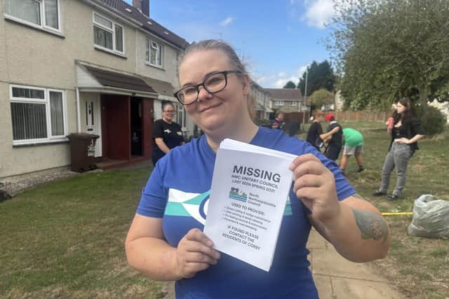 Sylvia Parkes is handing out leaflets saying 'Missing: NNC Unitary Council last seen Spring 2021. Used to provide grass cutting and hedge maintenance, litter picking and street cleaning, fly-tipping removal and enforcement, pavement and road sweeping. If found, please contact the residents of Corby'