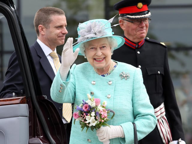 The Queen waving goodbye to the crowds waiting outside the Corby Cube in 2012