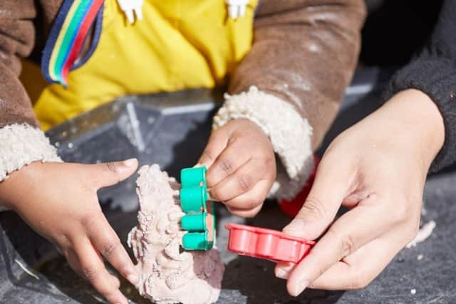 Hands of an adult and a child playing