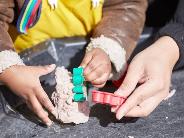Hands of an adult and a child playing