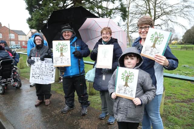 People stood outside the event with placards saying 'Save Our Trees'
