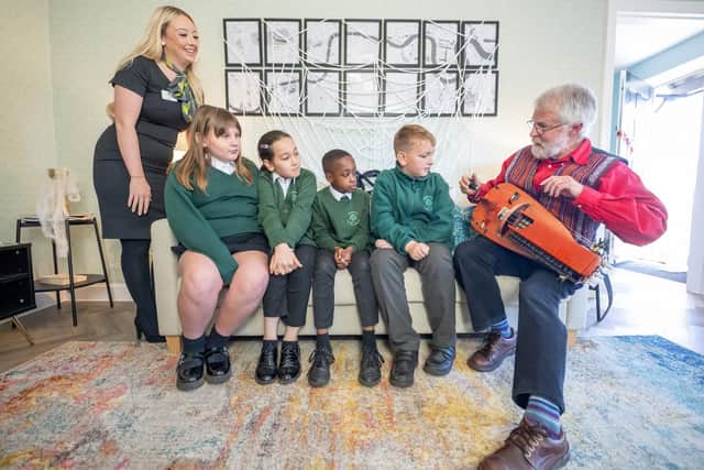 BN - SGB-8959 - Richard York demonstrating his hurdy-gurdy to some pupils and Jodie from Barratt Homes