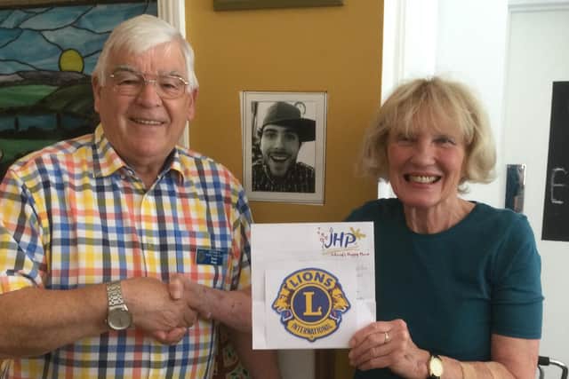 Founder and cornerstone of Johnny's Happy Place Denise is pictured accepting the cheque from Lion Dave.