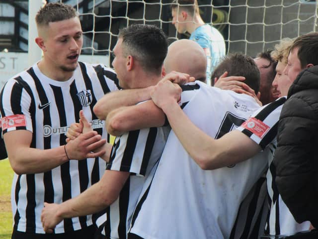 Elliot Sandy is mobbed by his team-mates after scoring Corby Town's equaliser against Shepshed Dynamo. Picture by David Tilley