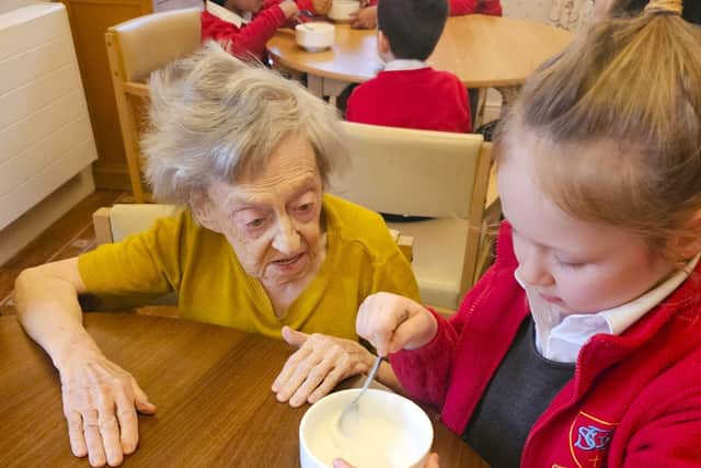 Resident Fiona concentrating on the icing being mixed by one of the pupils