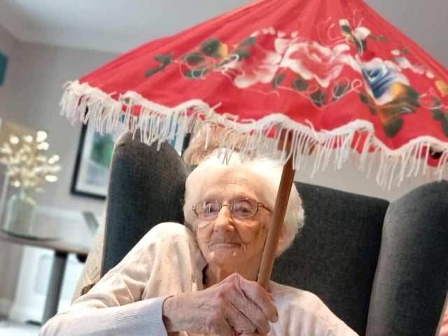 A care home resident sitting comfortably and enjoying the activities.