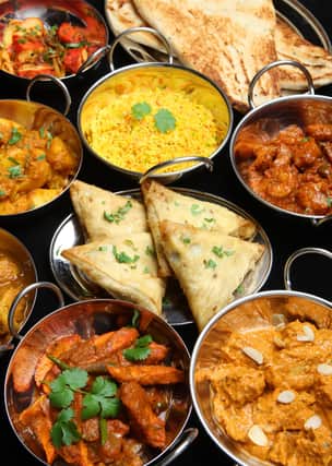 Selection of Indian food including curries, rice, samosas and naan bread.