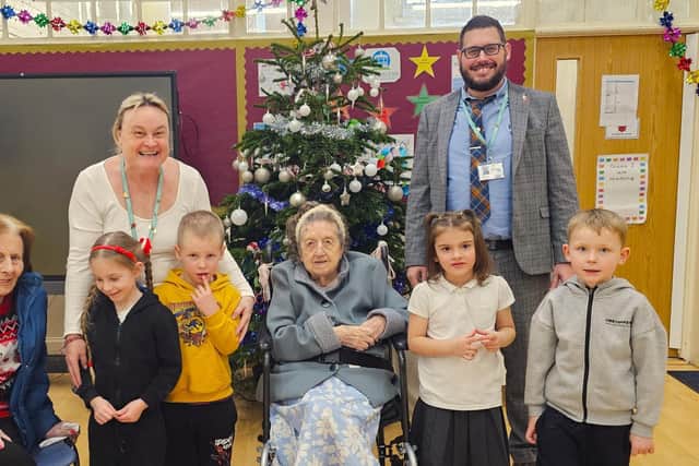 Head Teacher Liam Cox and Teaching Assistant Mrs Attwood with the pupils of Park Road Infant School and the residents of Elm Bank Care Home.