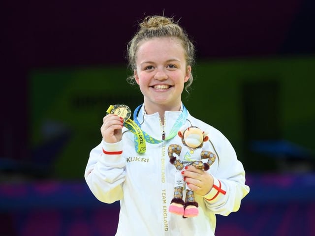 Maisie Summers-Newton of Team England shows her delight as she shows off her gold medal