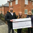 Encompass receive £250 from the HarperCrewe team at the Higham Ferrers development.
