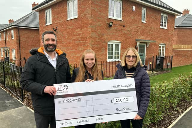 Encompass receive £250 from the HarperCrewe team at the Higham Ferrers development.