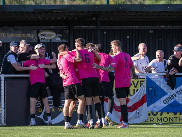 Corby Town's players and supporters celebrate Ben Challinor's late equaliser at Basford (Picture: Jim Darrah)