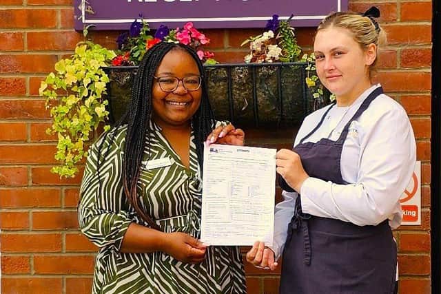 Home Manager, Marvellous Bindura with Head Chef, Sharntelle, holding the EHO inspection report.
