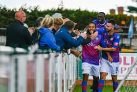 Nathan Hicks celebrates with his team-mates and the fans after he scored AFC Rushden & Diamonds' second goal in their much-needed 2-1 victory at Barwell. Picture by Hawkins Images