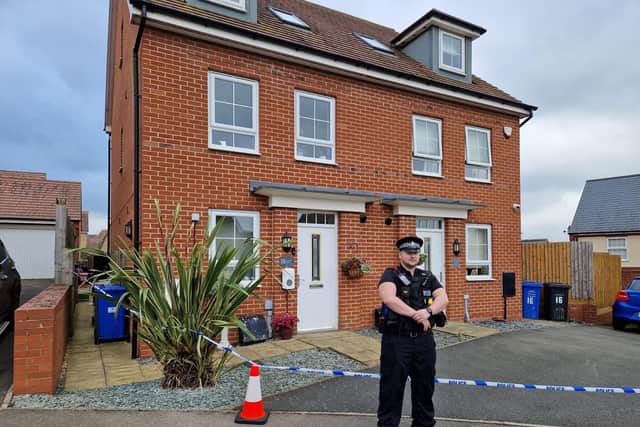 An officer stands guard at the home in Burton Latimer. Image: Alison Bagley