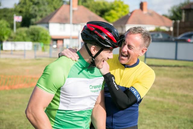 Saints player Ollie is congratulated by a fellow rider at the finish line at Cycle for Cransley 2022
