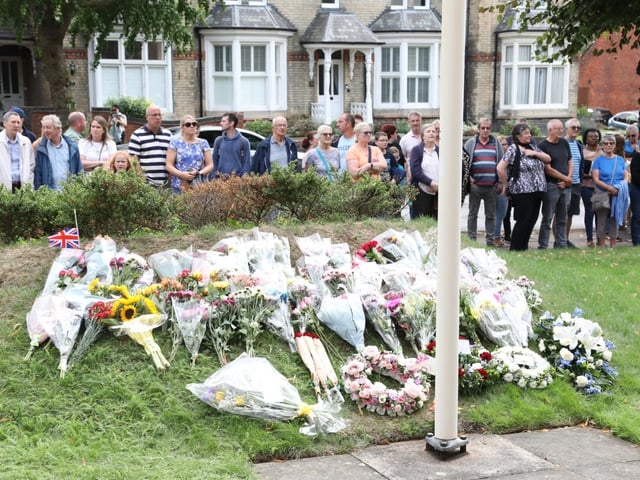 Flowers have been place around the flagpole, flying the union flag at half-mast