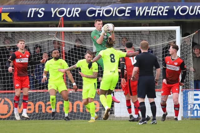 Debutant goalkeeper Owen Mason catches a cross for the Poppies