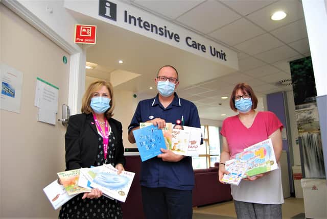 Intensive Care Unit Deputy Charge Nurse Andy Chatwin receives some of the books from KGH Organ and Tissue Donation Committee Chair Shirley Newman and incoming Chair Nicola Lee.