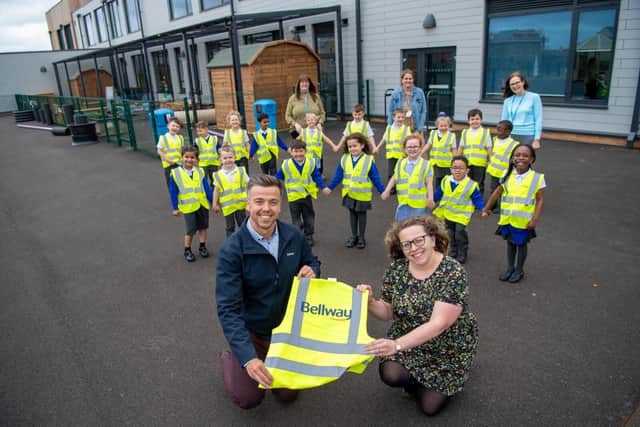Bellway Sales Manager Andrew Odams, with Head of School Sarah Whitlock and youngsters posing with their hi-vis jackets