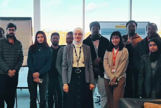 Dr Doaa Aljamal surrounded by her students.