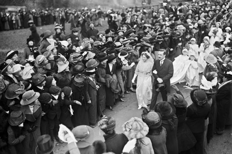 Crowds surround Lady Adelaide Margaret Spencer and Sir Sidney Cornwallis Peel as they make their way to their car after their wedding at Great Brington on 18th February 1914.