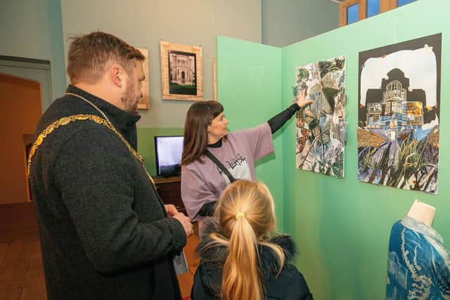A student shows their artwork to the mayor of Kettering on the exhibition's opening night.
