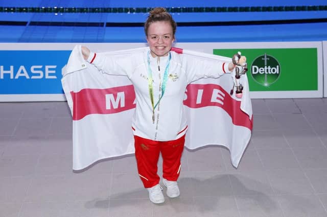 Maisie Summers-Newton poses with her gold medal and personalised flag after winning the women's 100m breaststroke SB6 final