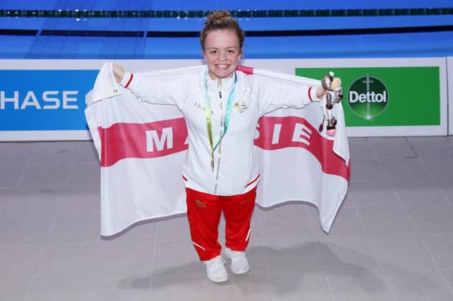 Maisie Summers-Newton poses with her gold medal and personalised flag after winning the women's 100m breaststroke SB6 final