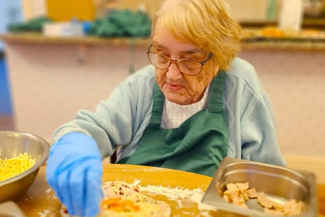 Elm Bank care home resident immersed in creating a pizza for 'National Pizza Day'