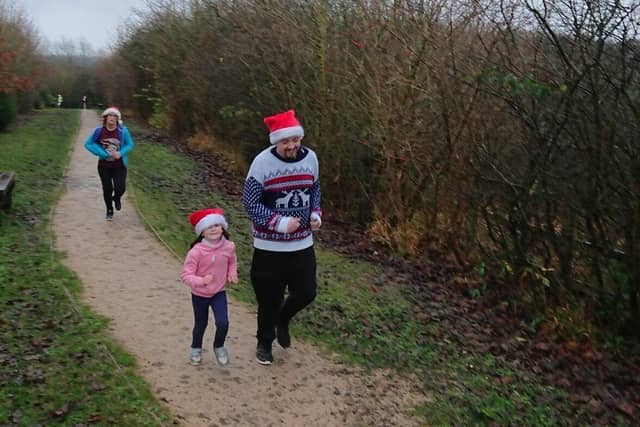 A man and child wearing Christmas hat at Desborough junior parkrun